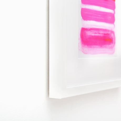 Pink abstract art in white frame at angle