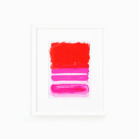 Red and pink abstract art in white frame on white wall